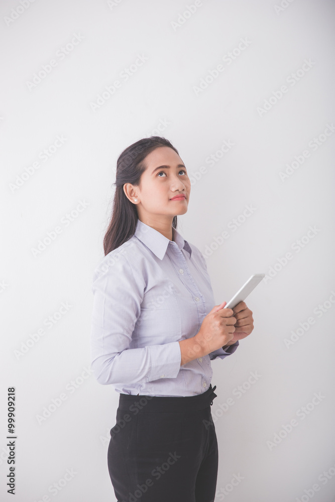 Asian Young secretary thinking while holding a mobile phone. Whi Asian Young secretary thinking while holding a mobile phone. Whi