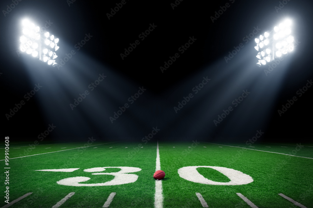 Football field at night with stadium lights