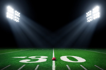 Football field at night with stadium lights