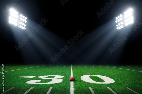 Football field at night with stadium lights