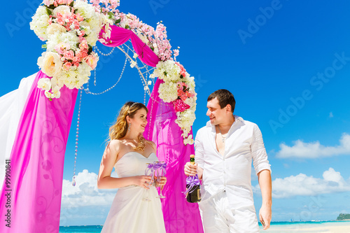 Wedding ceremony on a tropical beach in purple. Happy groom and