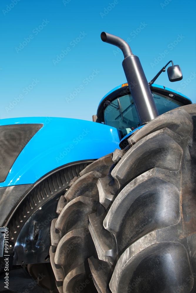 Naklejka premium Tire on blue tractor close up