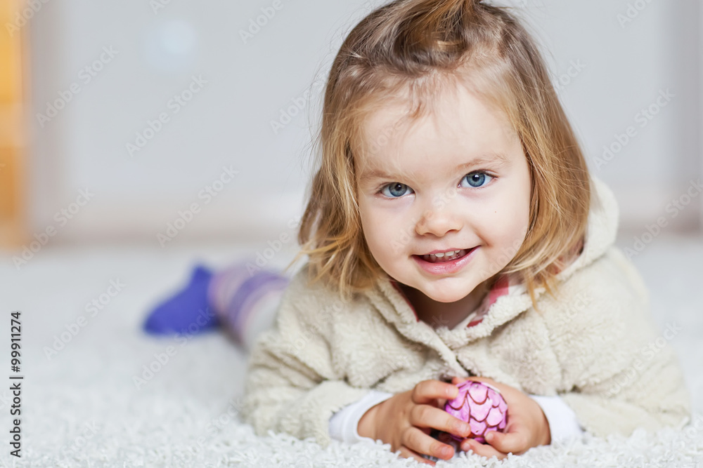 Fototapeta premium Happy little girl are liying in a carpet 