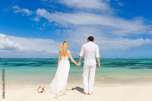 Bride and Groom having fun on the tropical beach with his back t © frolova_elena