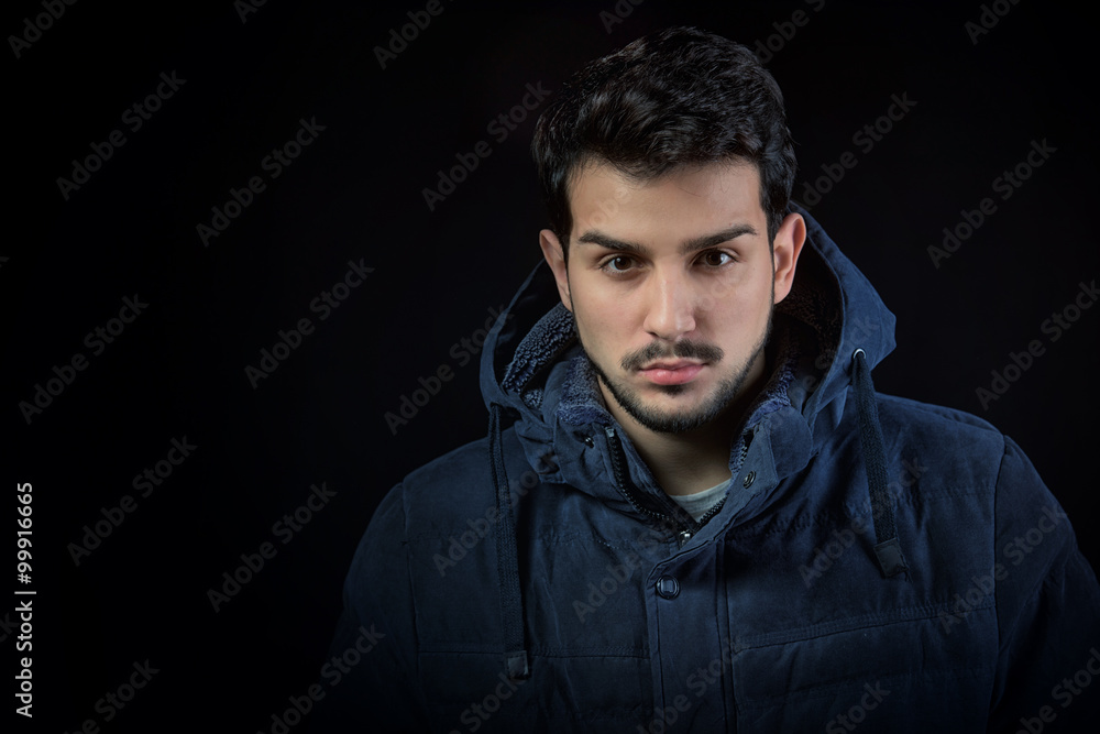 Man in winter jacket, studio shot, dark background