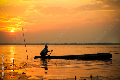 man in a boat on sunset sky 