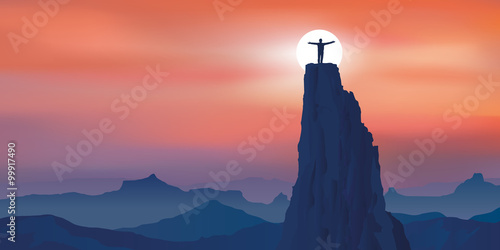 Concept de la réussite, avec un homme seul au sommet d’une montagne qui écarte les bras en signe de victoire, après avoir atteint son objectif.