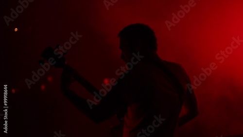 Bass player on the stage playing live with smoke