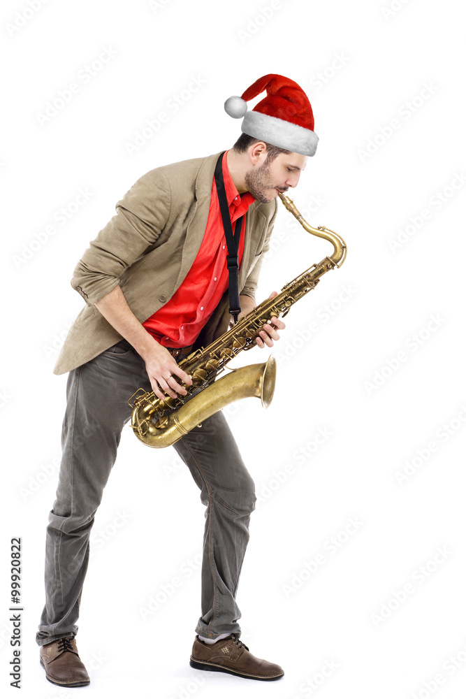 Naklejka premium man saxophonist in Santa hat playing saxophone player in studio