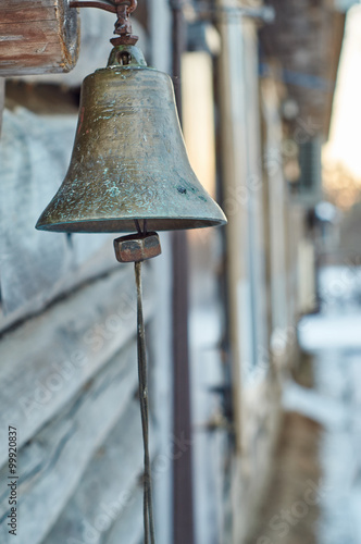  Bell hanging on the old wooden house in the village 