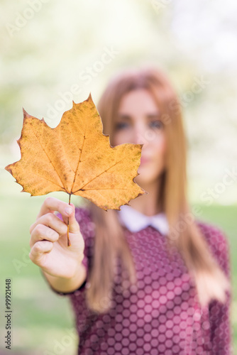 Girl holding a yellow autumn leaf