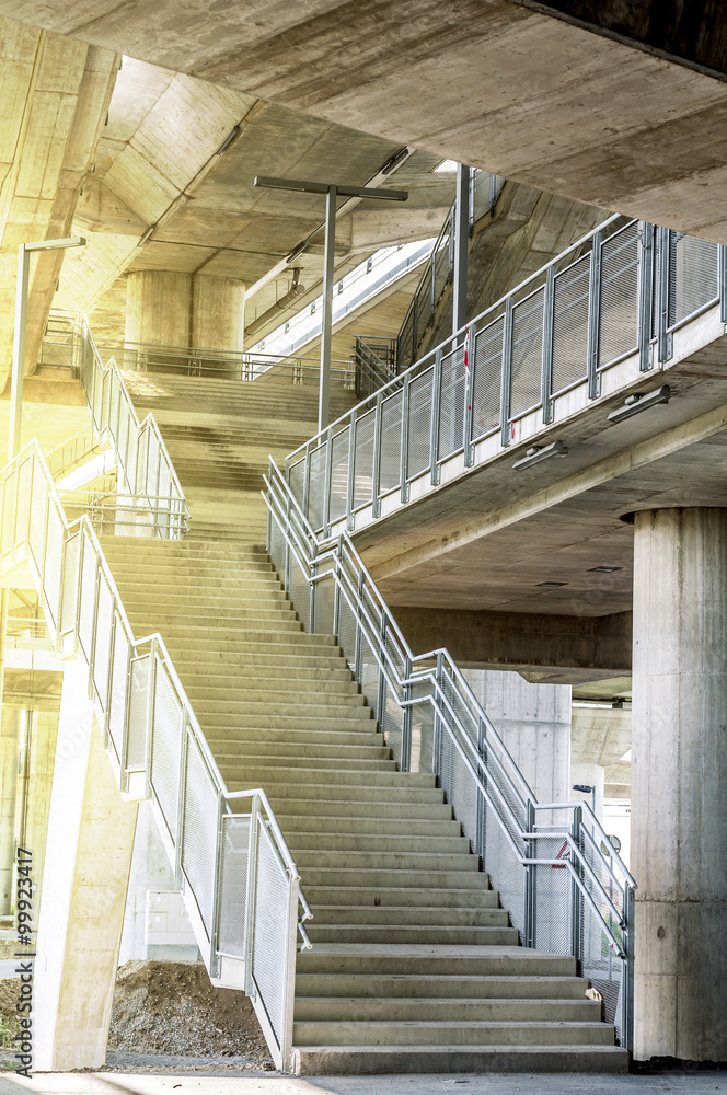Fototapeta premium Marble stairs under the bridge with oragne sun