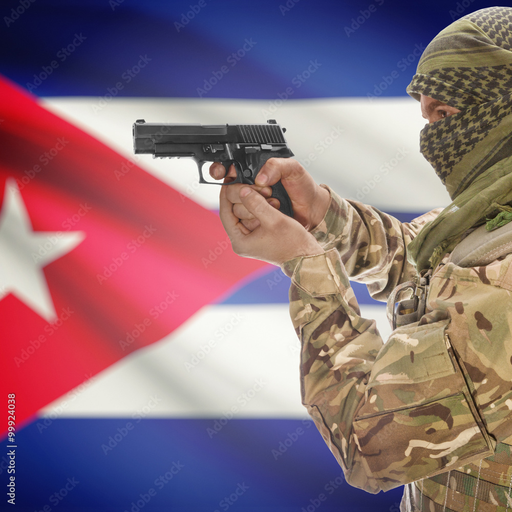 Fototapeta premium Male with gun in hands and national flag on background - Cuba