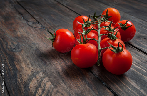 Fresh cherry tomatoes on wood background