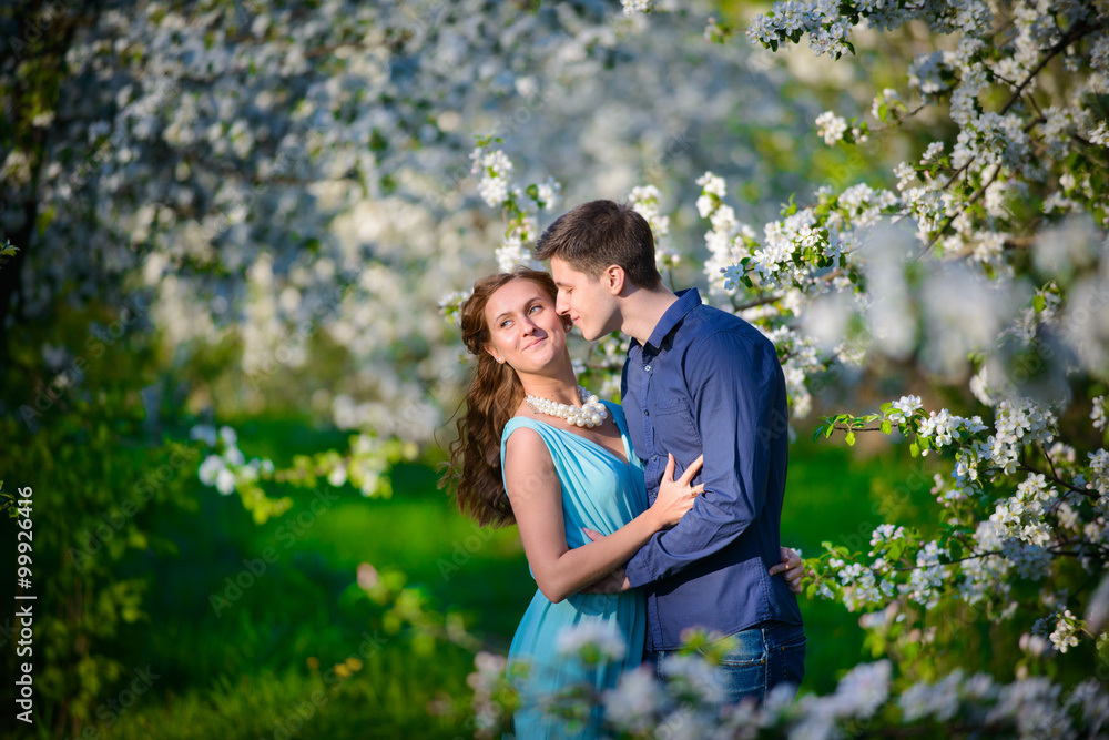 Young beautiful couple in love among apple trees Young beautiful couple in love among apple trees