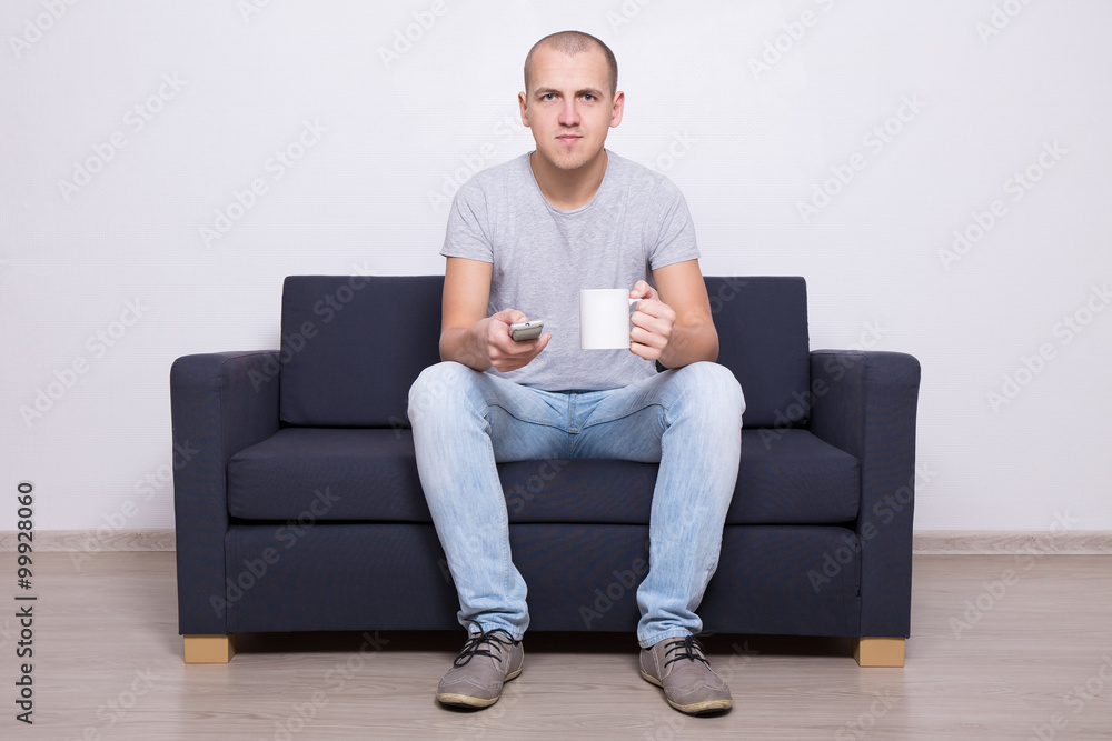 handsome man watching tv with cup of tea handsome man watching tv with cup of tea