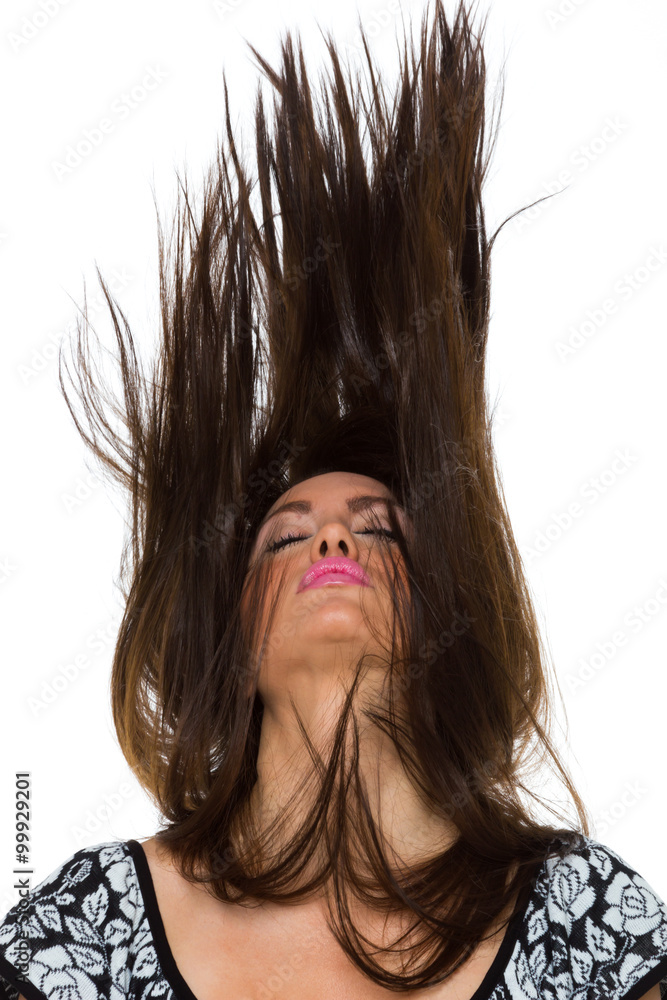Young woman dancing with her long hair fluttering in motion Young woman dancing with her long hair fluttering in motion
