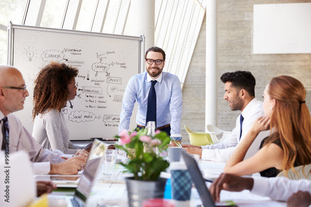 Caucasian Businessman Leading Meeting At Boardroom Table Caucasian Businessman Leading Meeting At Boardroom Table
