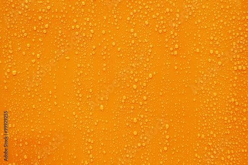 Close up water drop on dark orange background.