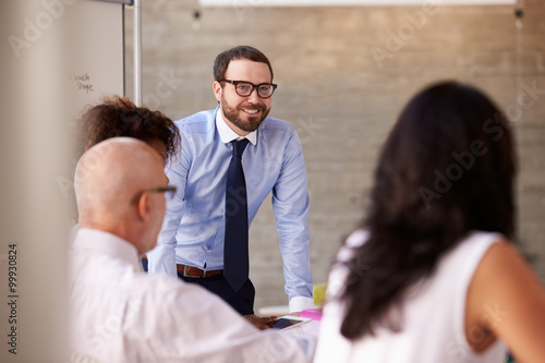 Caucasian Businessman Leading Meeting At Boardroom Table