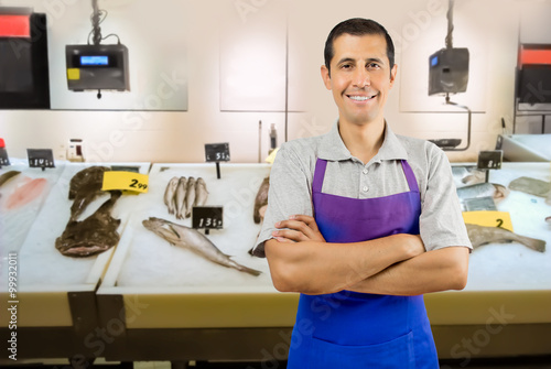 Photos fishmonger in fish shop wearing black apron