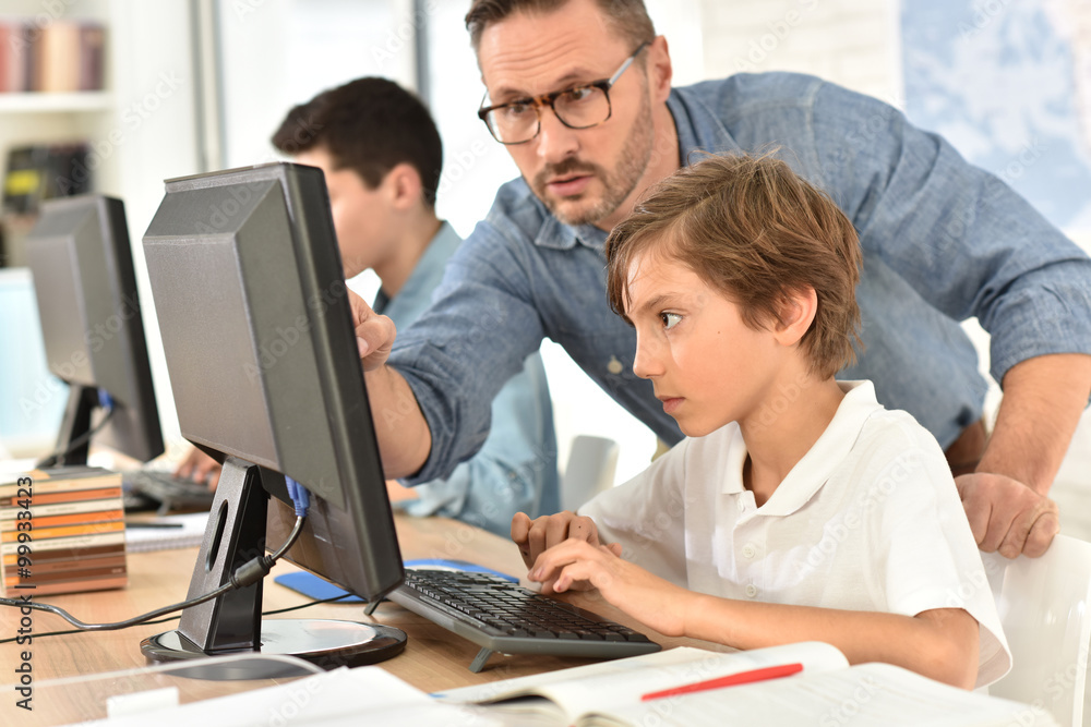 Teacher with kids in computing class Teacher with kids in computing class