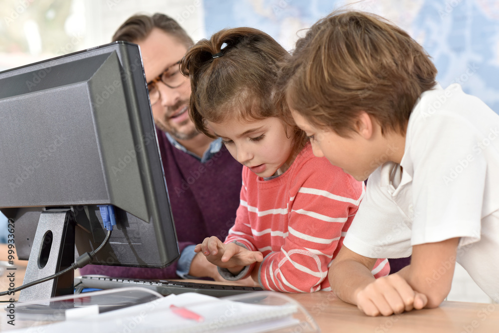 Teacher with kids in computing class Teacher with kids in computing class