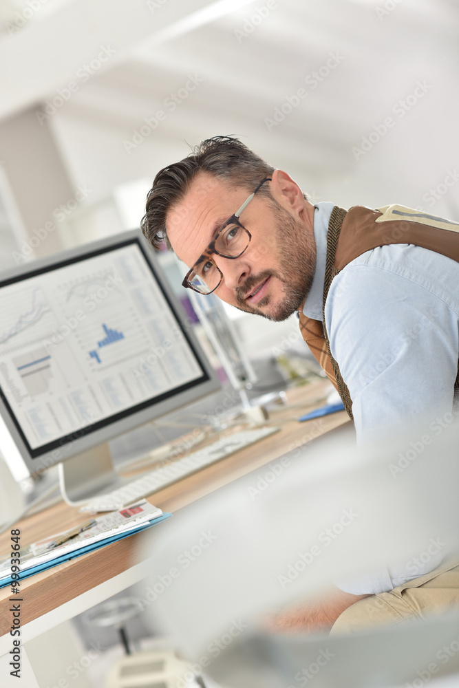 Middle-aged businessman with eyeglasses in office Middle-aged businessman with eyeglasses in office
