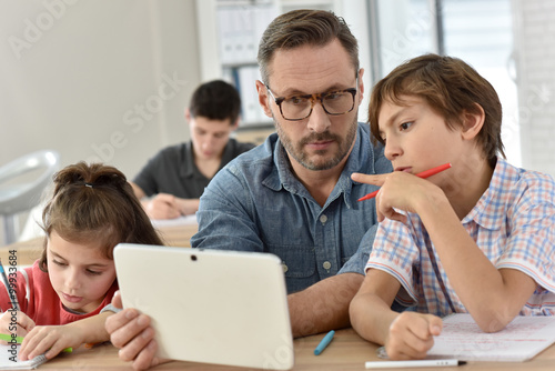 Teacher with students in class using digital tablet