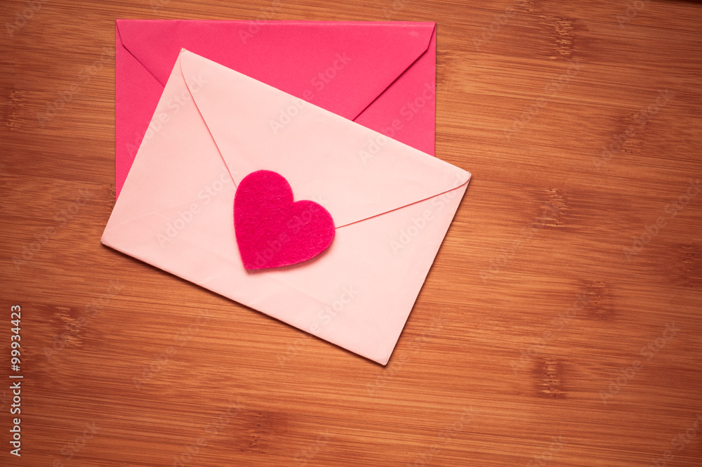 Love letters on wooden table. Pink envelopes with heart top view. 