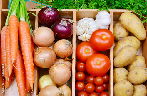 Carrots,onion,red onion,garlic,tomatoes,potatoes.
a lot of colorful vegetable in the kitchen.