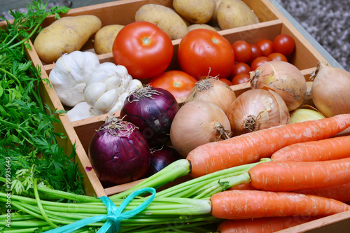 Carrots onion red onion garlic tomatoes potatoes.  a lot of colorful vegetable in the kitchen.