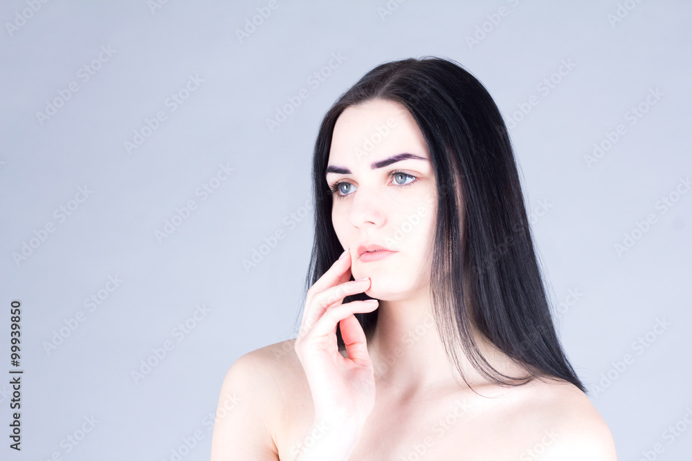 Woman with dark hair touching the cheek by hand. Beauty concept Woman with dark hair touching the cheek by hand. Beauty concept