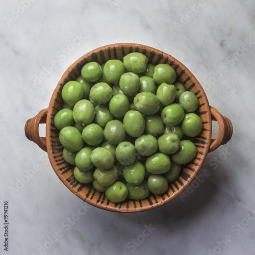 Castelvetrano Green Olives:  Bright green Sicilian Olives in brine, in a patterned terracotta bowl