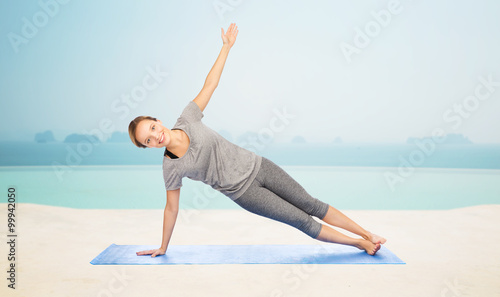 woman making yoga in side plank pose on mat