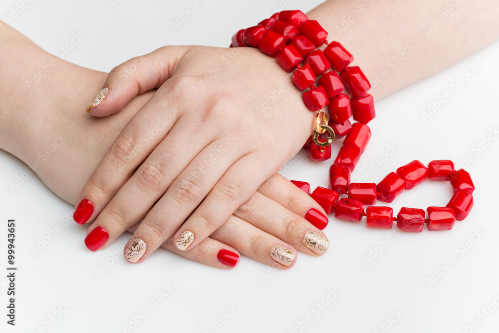 Woman hands with red and gold manicure Woman hands with red and gold manicure