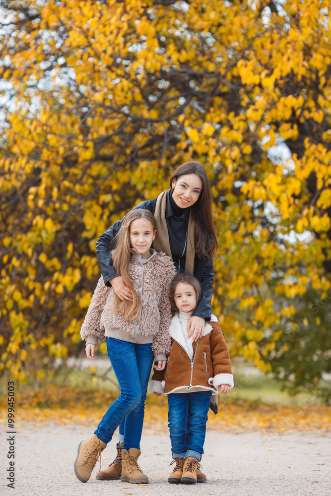 Family portrait of sisters in yellow autumn Park Family portrait of sisters in yellow autumn Park
