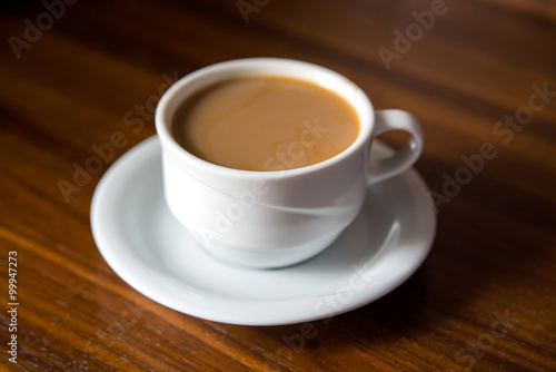 Cup of coffee with milk on a wooden table