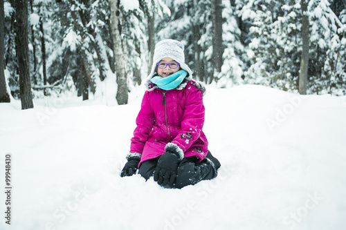 Little Girl Playing with Snow Outdoors in Winter