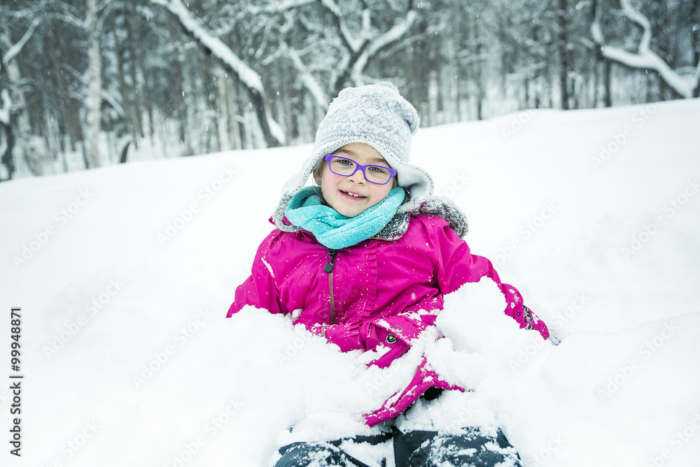 Little Girl Playing with Snow Outdoors in Winter