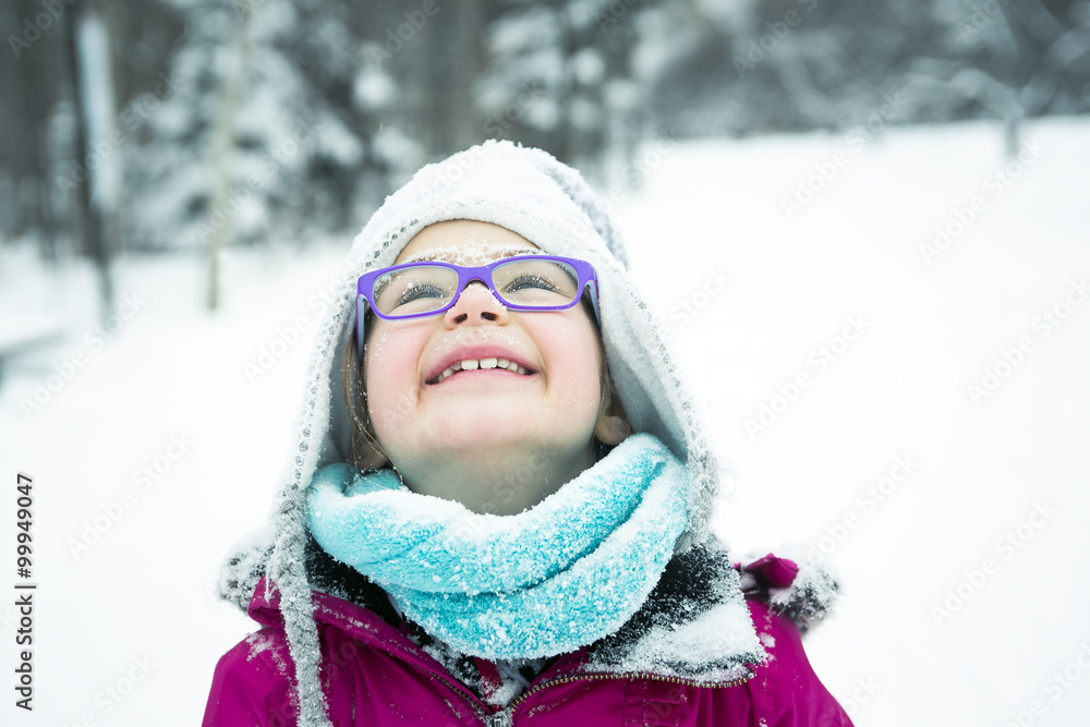 Little Girl Playing with Snow Outdoors in Winter
