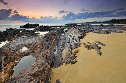 Stunning time lapse during sunrise at rocky beach near Tanjung