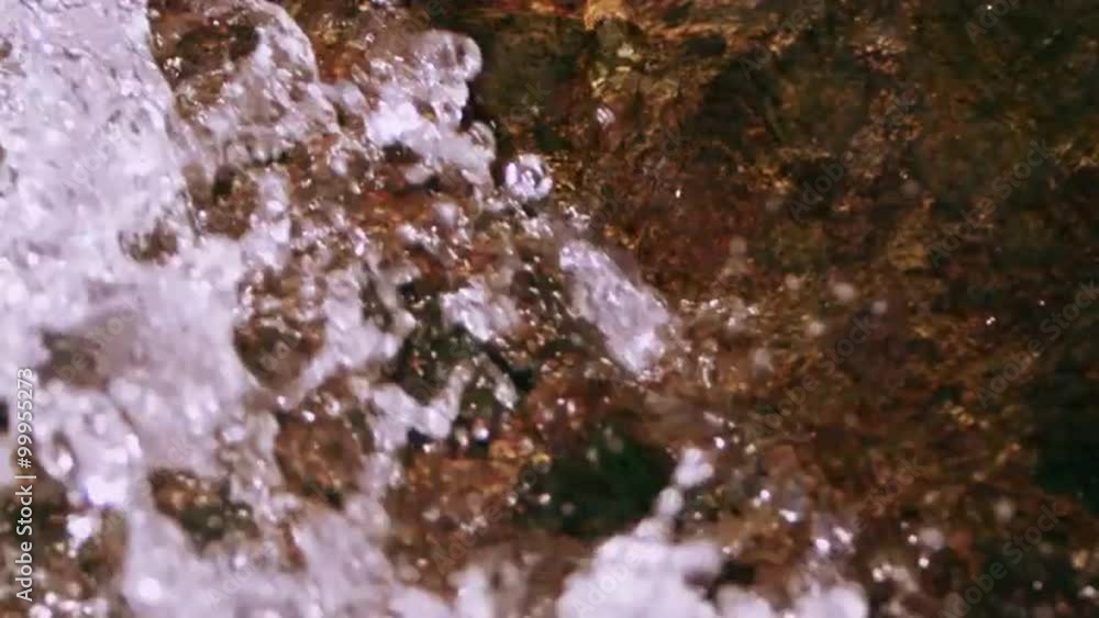 Close up rushing water splashing over rocks. Slow motion. Close up rushing water splashing over rocks. Slow motion.