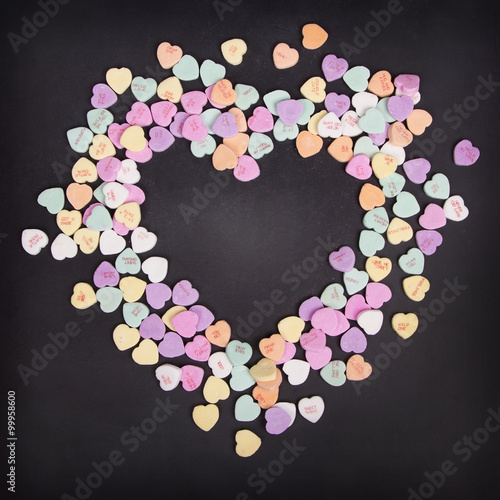 Candy conversation hearts on a chalkboard