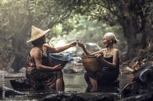 Canvas Print Old Asian woman working in cascade, Thailand
