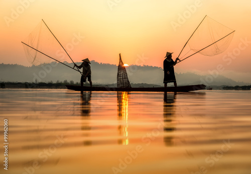 Fisherman in action when fishing in the lake , Thailand photo