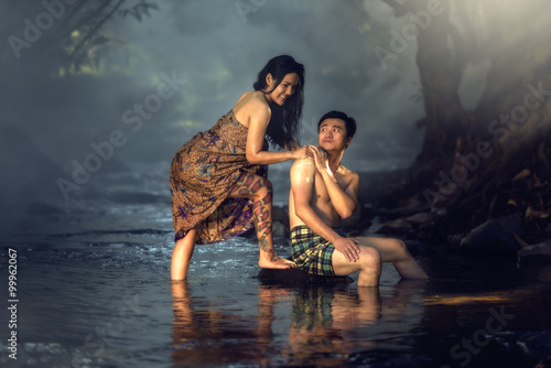 Asian couple bathing at cascade in Thailand countryside