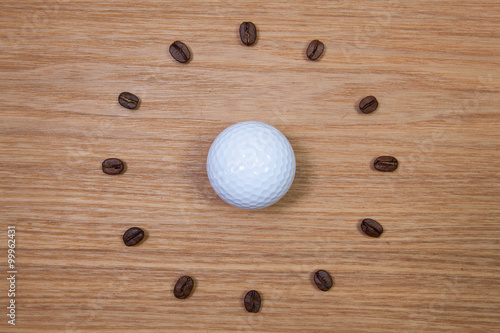 White golf ball and clock of coffee beans