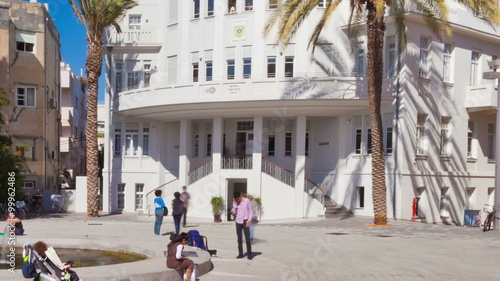 Panning shot of Time lapse of a busy plaza in front of a white building photo