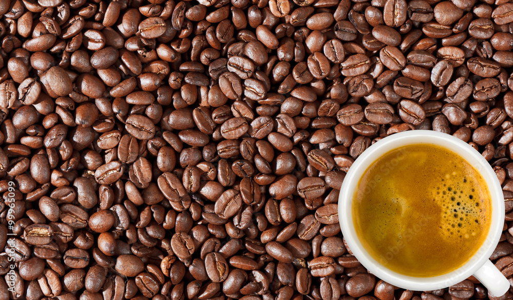 Fototapeta premium Close-up of coffee beans background and white coffee cup